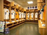 足球更衣室内景展示，球员球衣整齐悬挂备战比赛